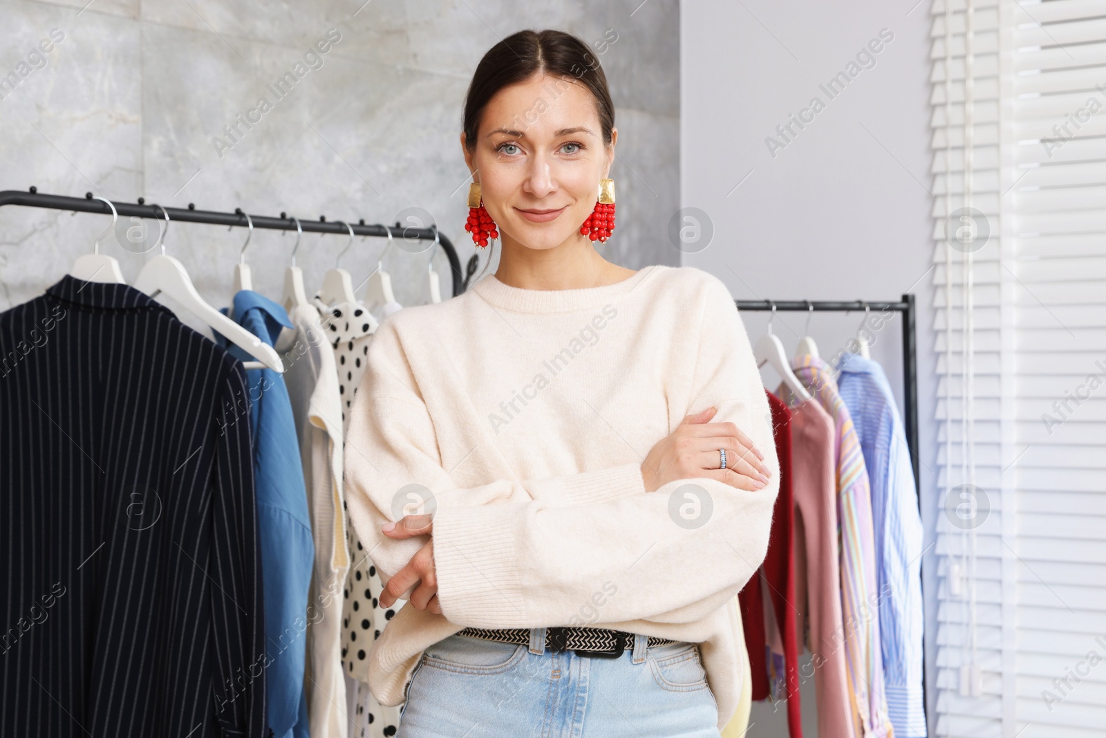 Portrait of professional stylist near clothing rack indoors Photo of Portrait of professional stylist near clothing rack indoors