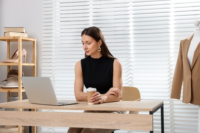 Photo of Professional stylist having online consultation with client via laptop at desk indoors