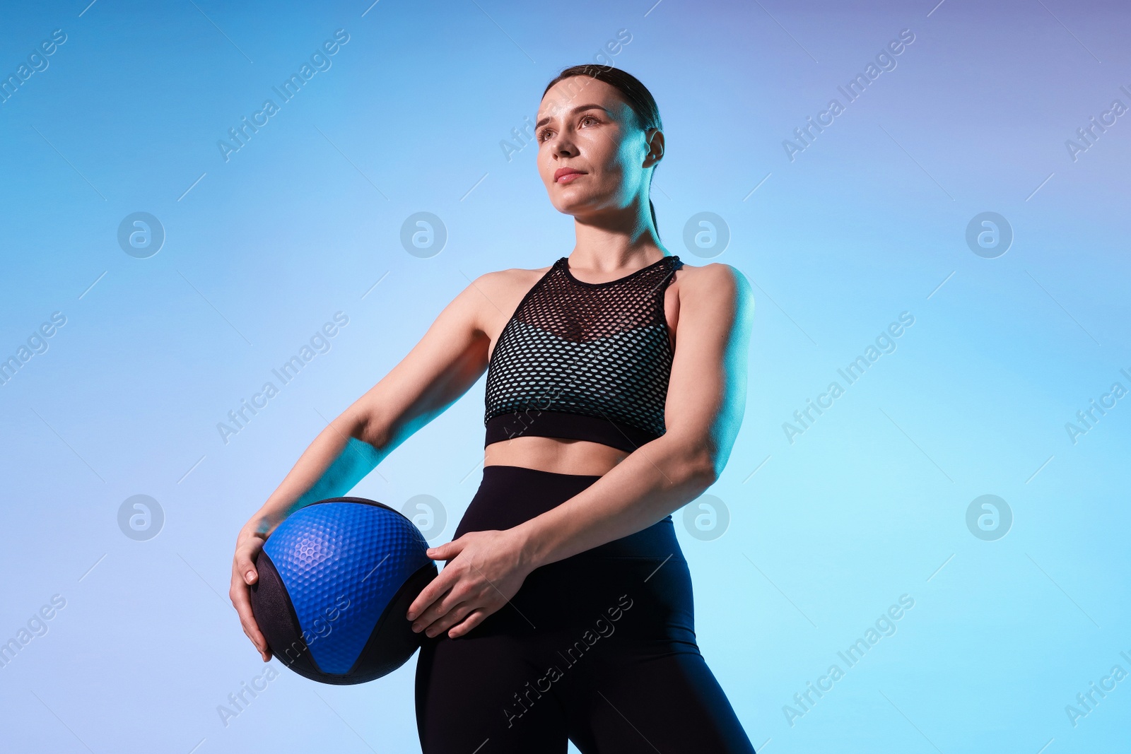 Woman with medicine ball on color background Photo of Woman with medicine ball on color background