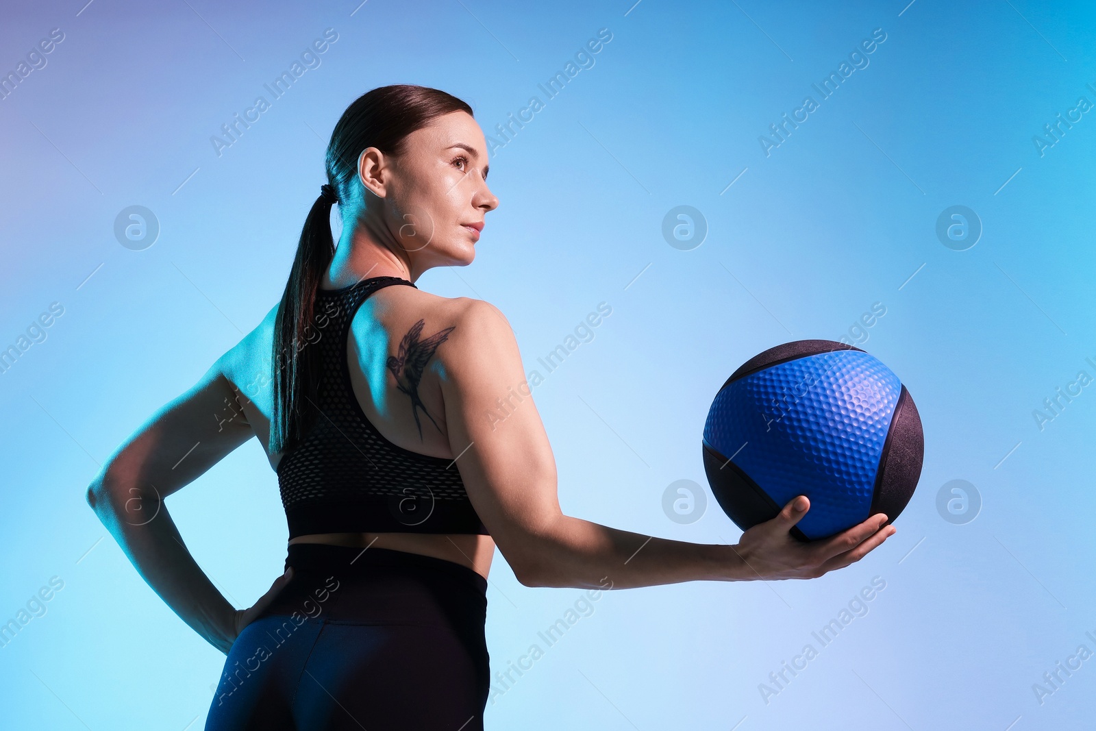 Woman with medicine ball on color background Photo of Woman with medicine ball on color background