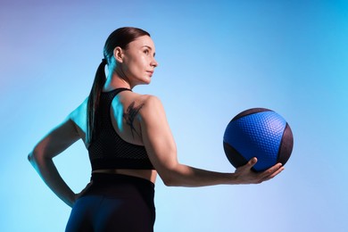 Photo of Woman with medicine ball on color background