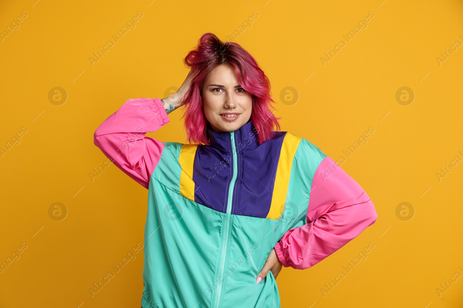 Beautiful woman with pink dyed hair on yellow background Photo of Beautiful woman with pink dyed hair on yellow background
