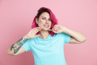 Photo of Beautiful woman with bright dyed hair on pink background