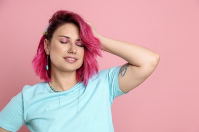 Photo of Beautiful woman with bright dyed hair on pink background