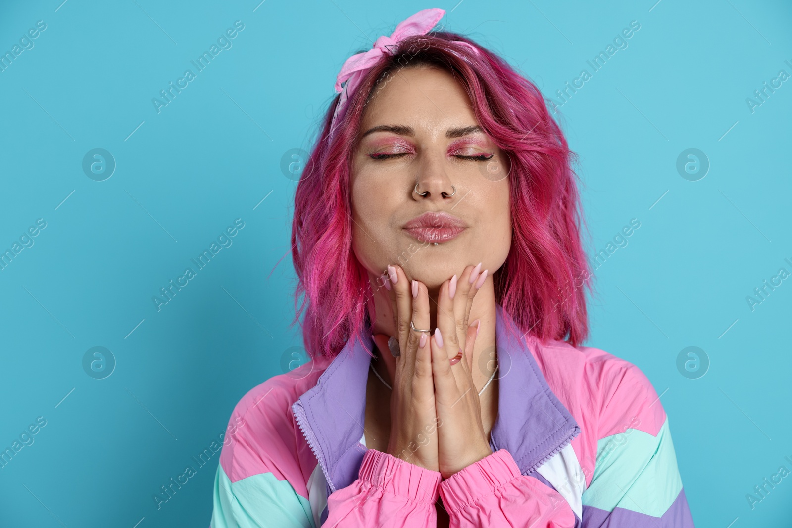 Beautiful woman with pink dyed hair on light blue background Photo of Beautiful woman with pink dyed hair on light blue background
