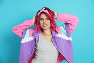 Photo of Beautiful woman with pink dyed hair on light blue background