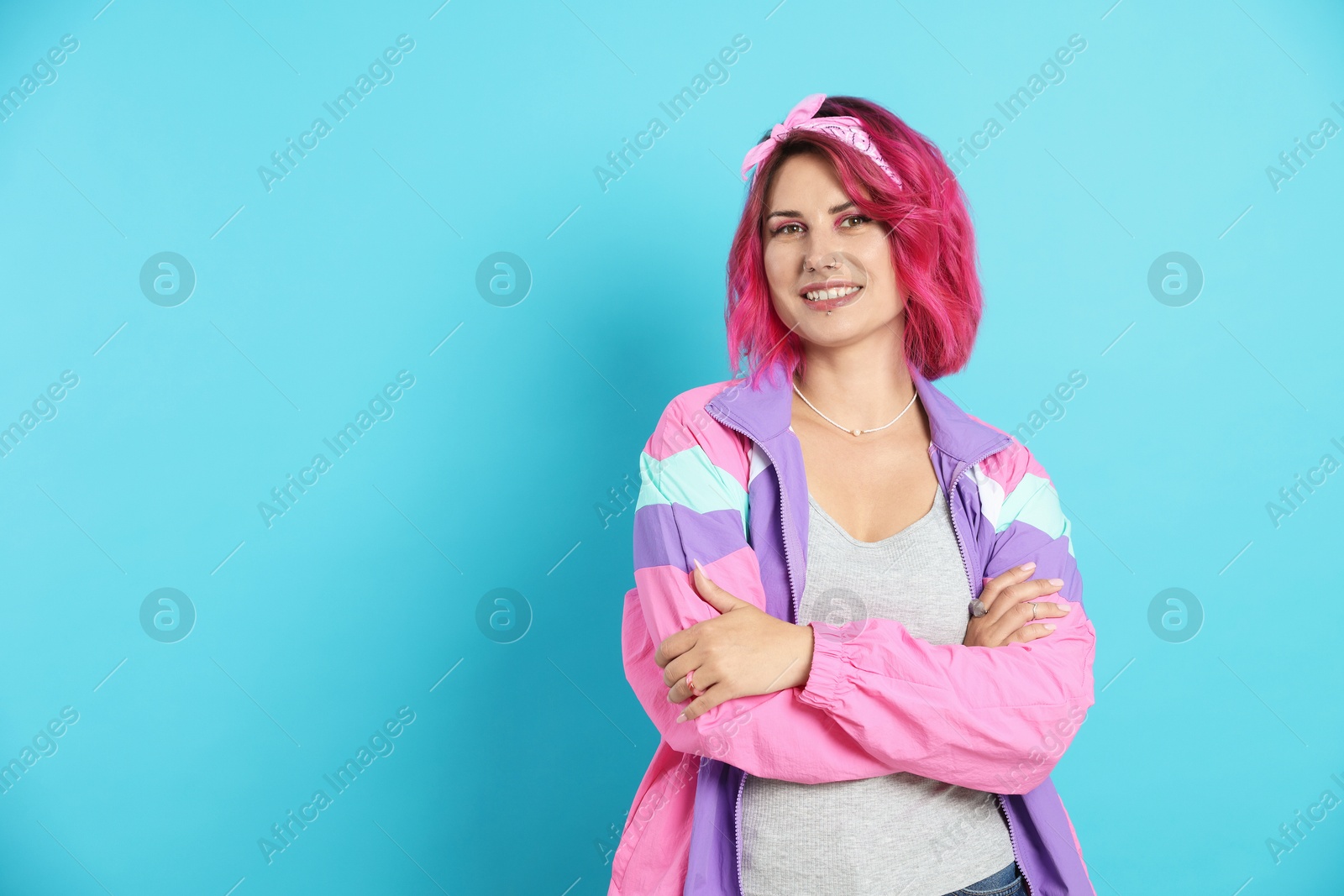 Beautiful woman with pink dyed hair on light blue background, space for text Photo of Beautiful woman with pink dyed hair on light blue background, space for text