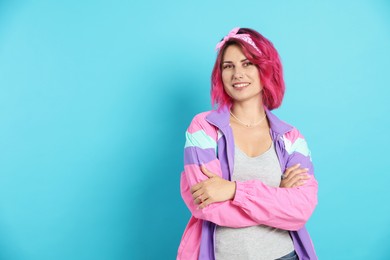 Photo of Beautiful woman with pink dyed hair on light blue background, space for text