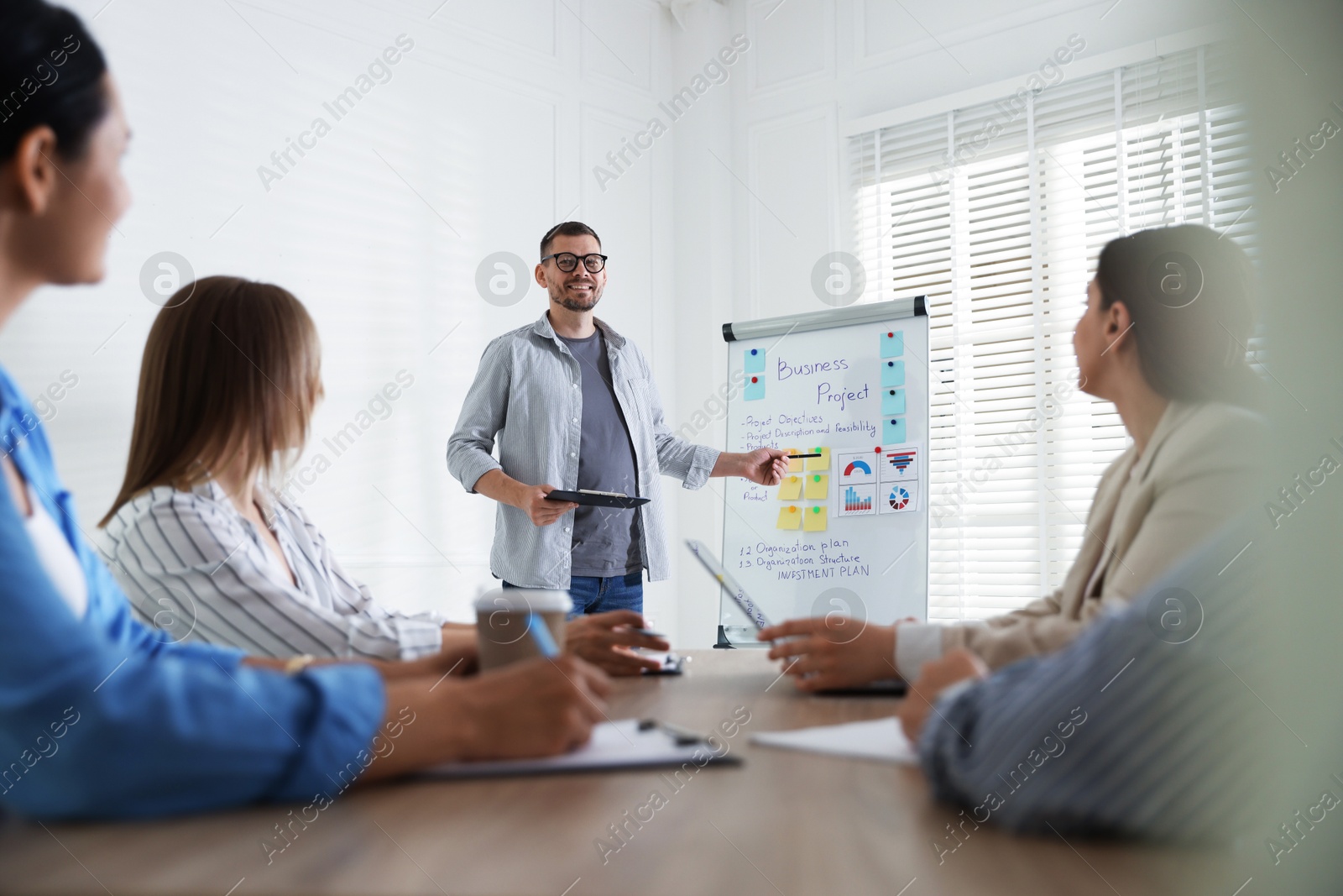 Man giving public speech in front of audience indoors Photo of Man giving public speech in front of audience indoors