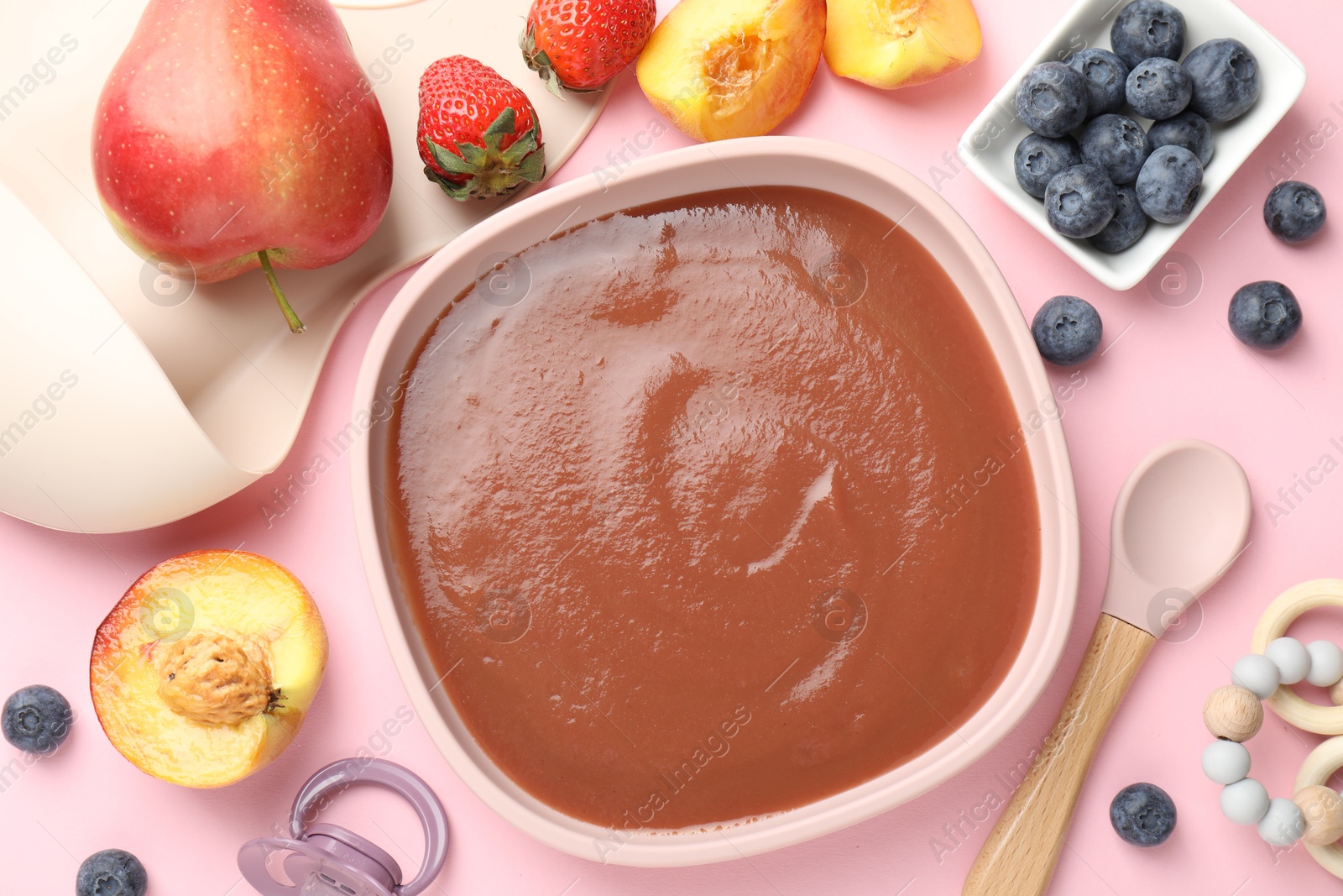 Baby food. Tasty puree in bowl, spoon and ingredients on pink table, flat lay Photo of Baby food. Tasty puree in bowl, spoon and ingredients on pink table, flat lay