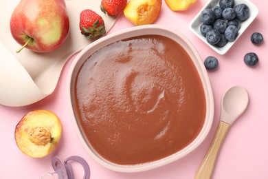 Photo of Baby food. Tasty puree in bowl, spoon and ingredients on pink table, flat lay