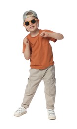 Photo of Happy little boy with sunglasses dancing on white background
