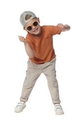 Photo of Happy little boy with sunglasses dancing on white background