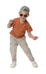 Photo of Happy little boy with sunglasses dancing on white background