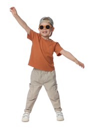 Photo of Happy little boy with sunglasses dancing on white background