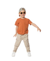 Photo of Happy little boy with sunglasses dancing on white background