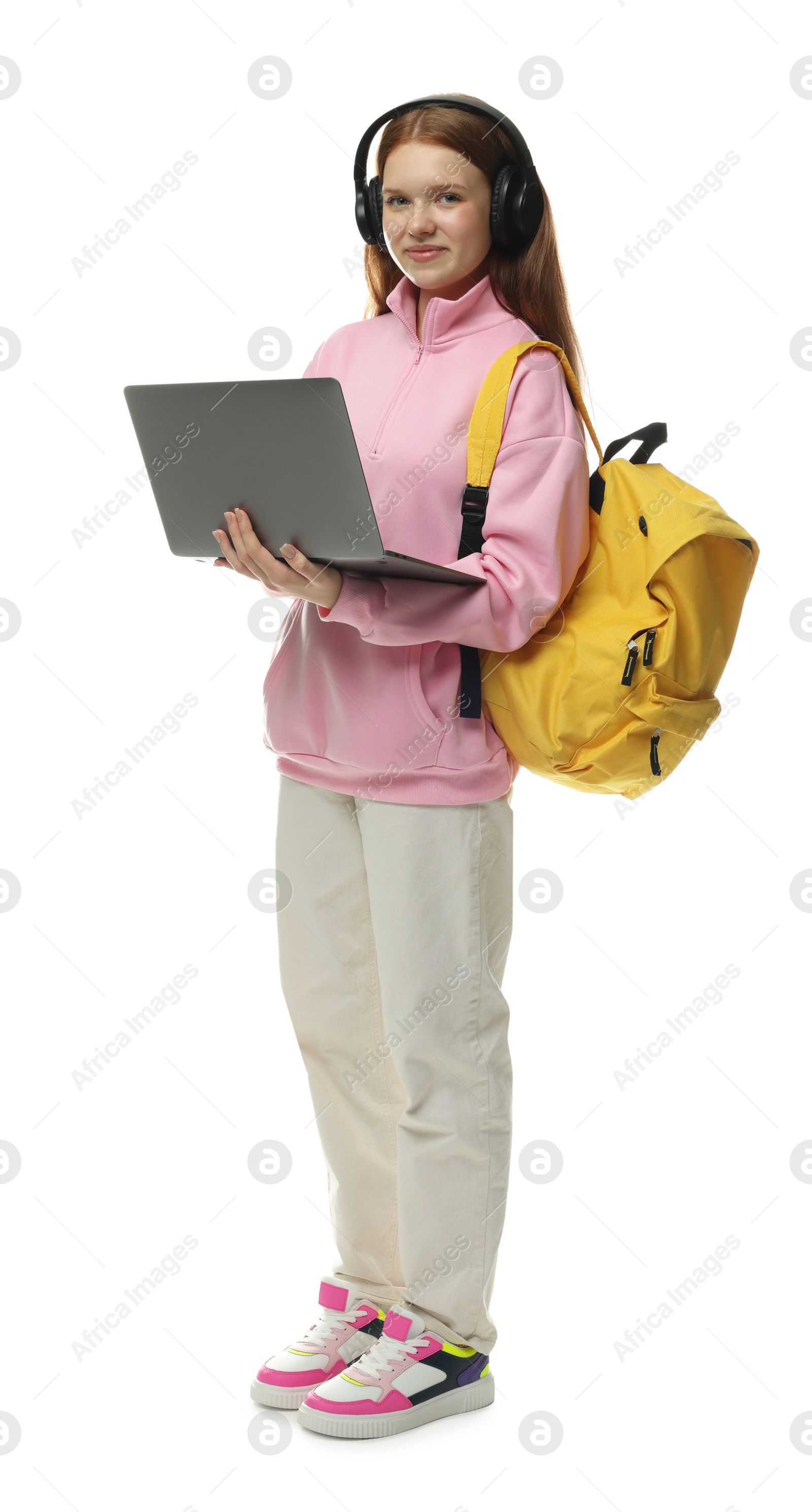 Teenage girl with laptop, headphones and backpack on white background Photo of Teenage girl with laptop, headphones and backpack on white background