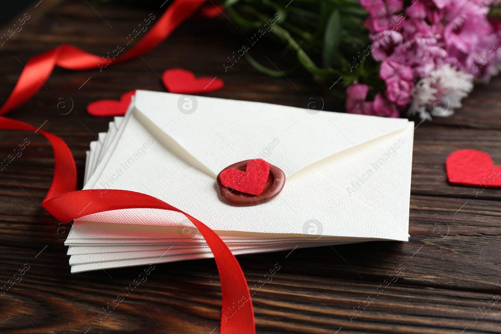 Stack of love letters, red hearts and beautiful flowers on wooden table, closeup Photo of Stack of love letters, red hearts and beautiful flowers on wooden table, closeup