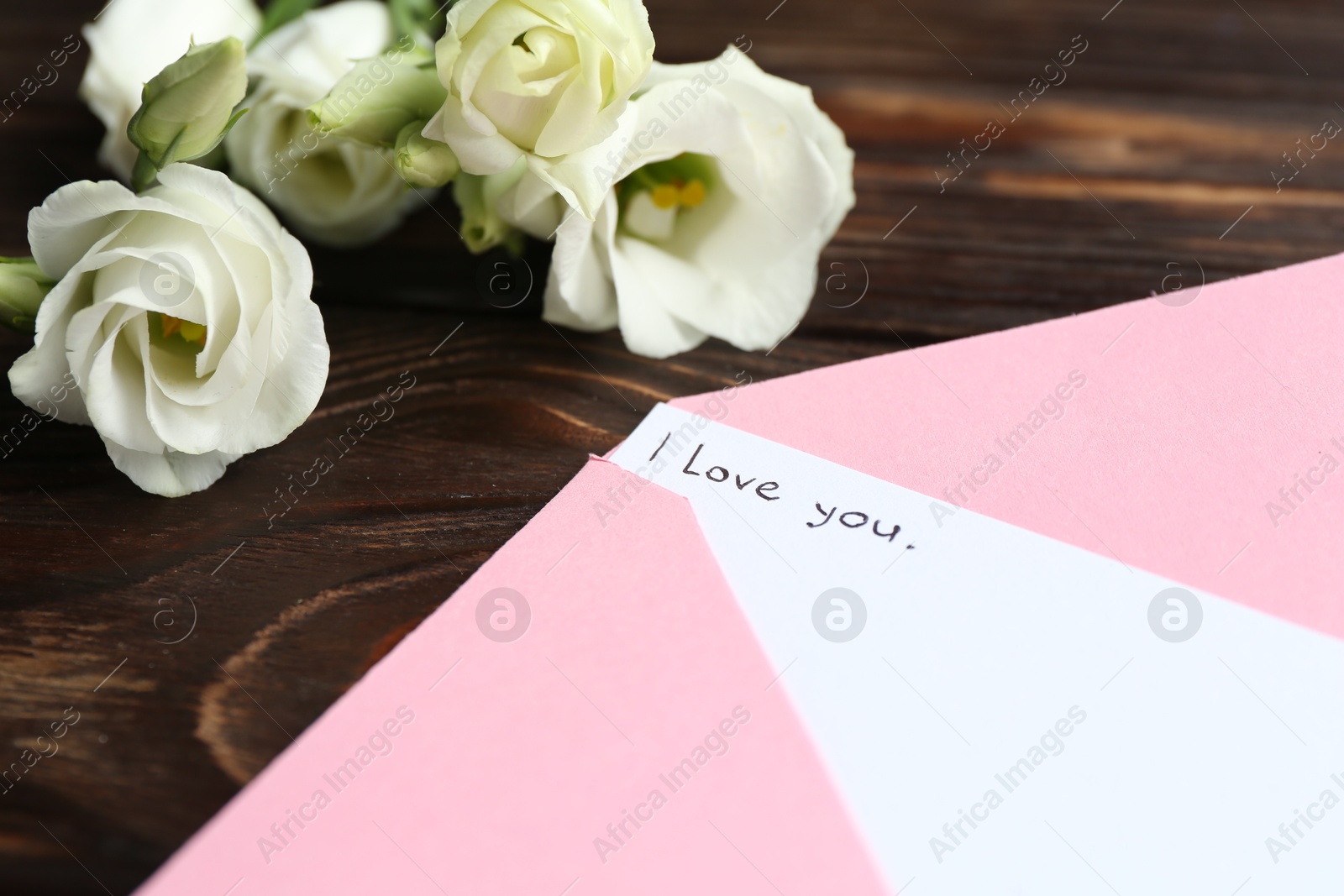 Letter with phrase I Love You, envelope and beautiful flowers on wooden table, closeup Photo of Letter with phrase I Love You, envelope and beautiful flowers on wooden table, closeup