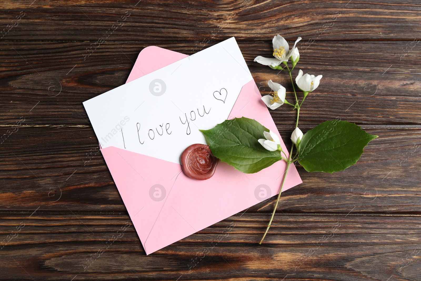 Letter with phrase I Love You, envelope and beautiful flowers on wooden table, flat lay Photo of Letter with phrase I Love You, envelope and beautiful flowers on wooden table, flat lay