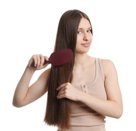 Photo of Beautiful teenage girl brushing her shiny hair on white background