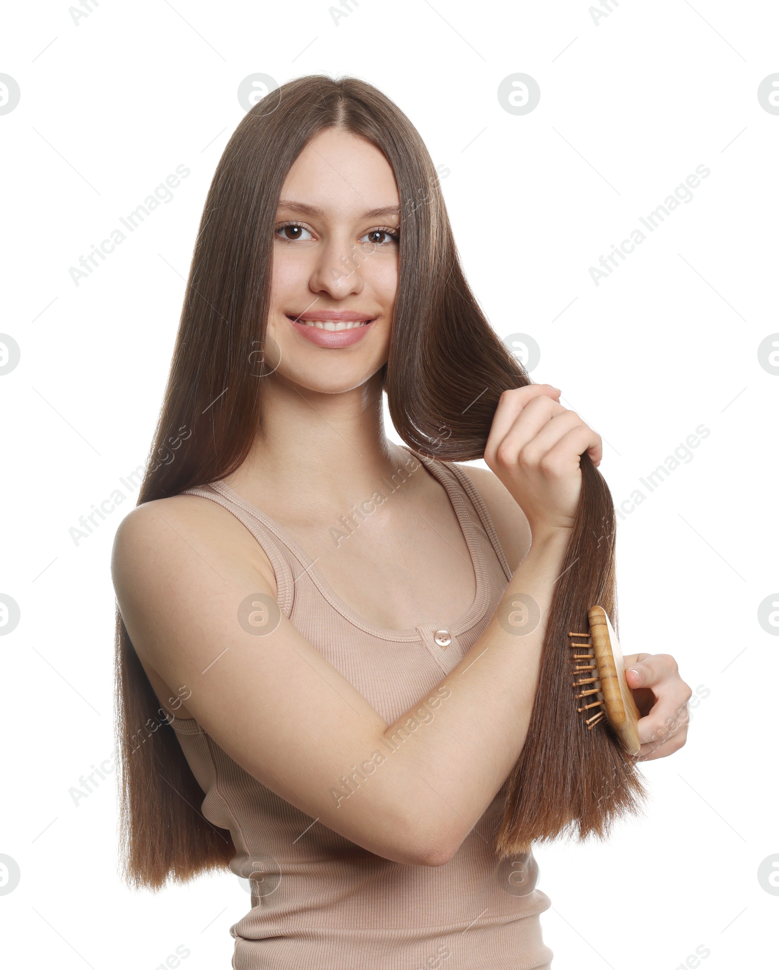 Smiling teenage girl brushing her shiny hair on white background Photo of Smiling teenage girl brushing her shiny hair on white background
