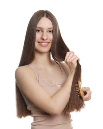 Photo of Smiling teenage girl brushing her shiny hair on white background