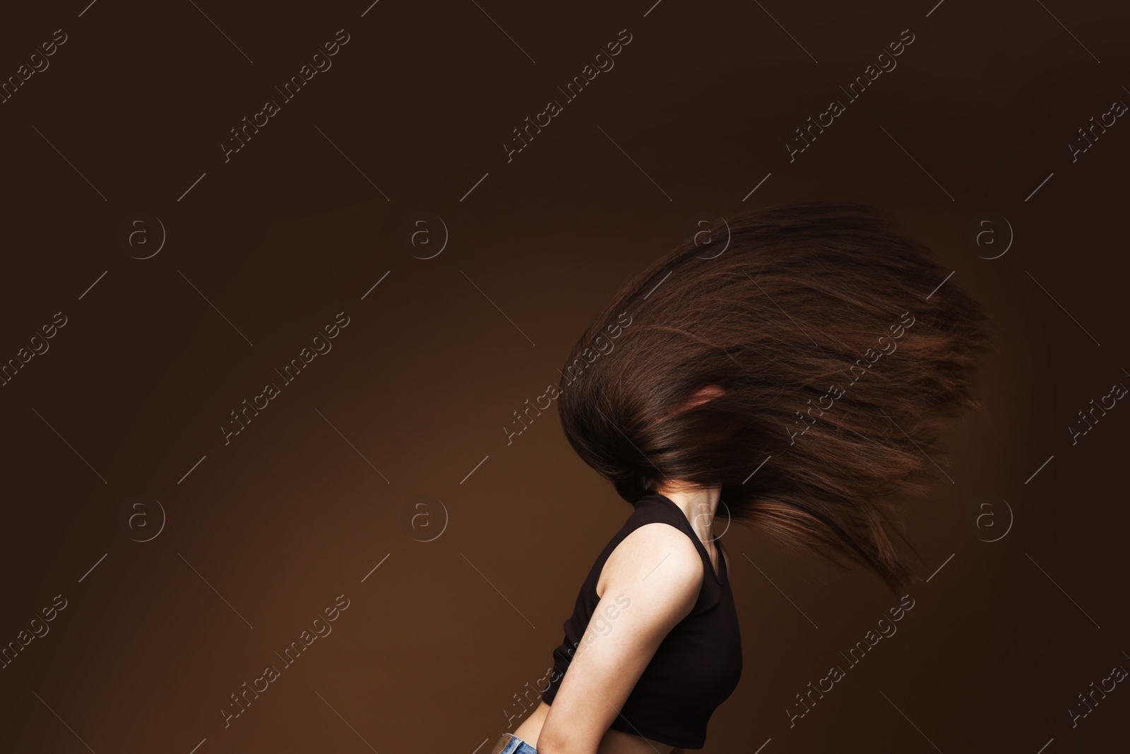 Teenage girl with healthy long hair on brown background. Space for text Photo of Teenage girl with healthy long hair on brown background. Space for text