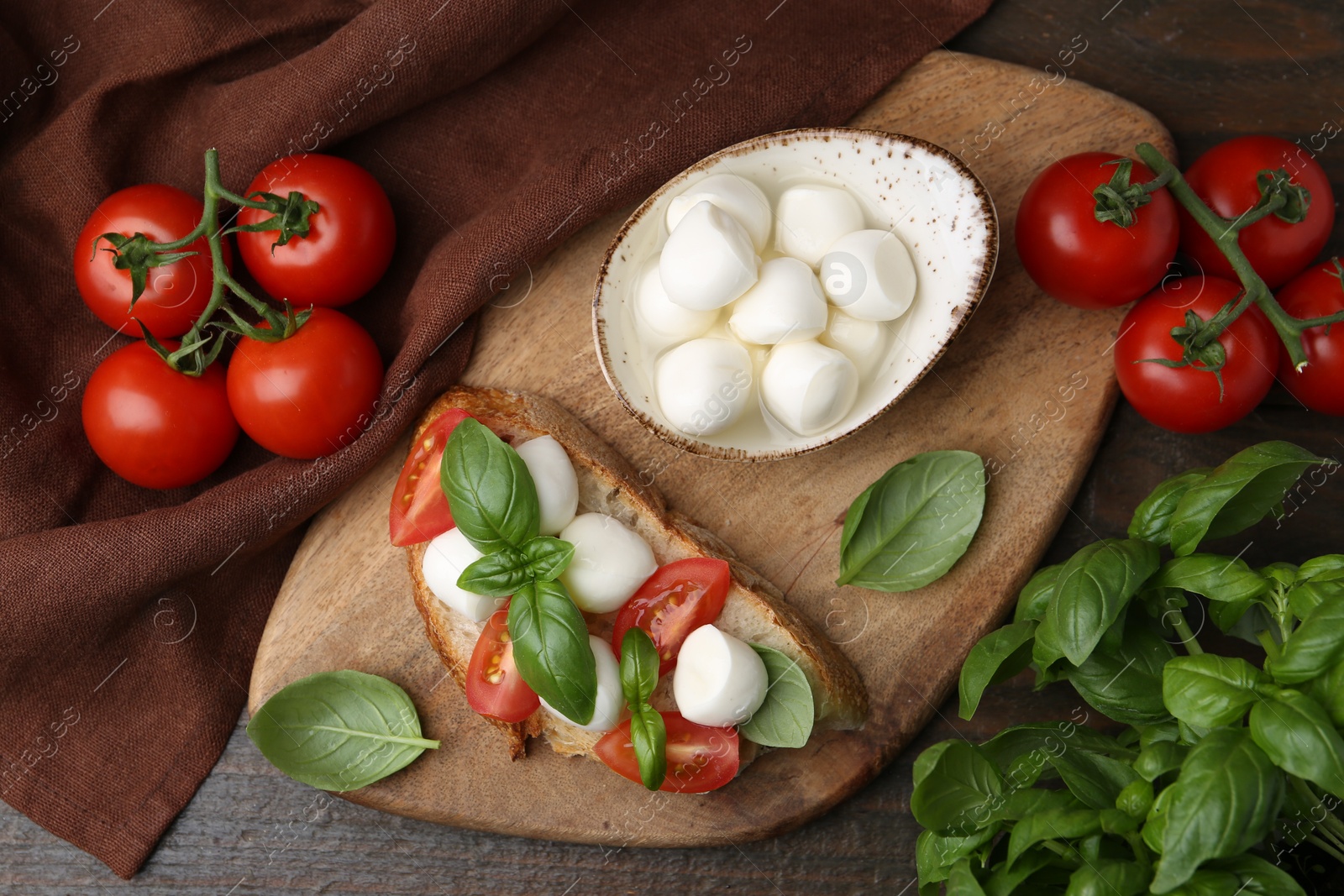 Tasty sandwich with mozzarella cheese, tomatoes and basil on wooden table, flat lay Photo of Tasty sandwich with mozzarella cheese, tomatoes and basil on wooden table, flat lay