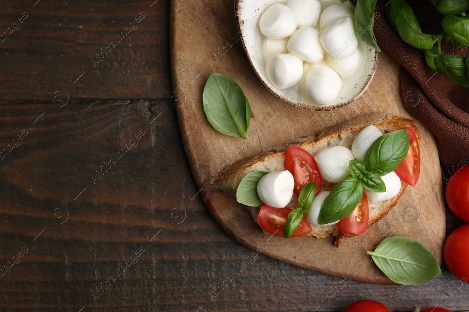 Tasty sandwich with mozzarella cheese, tomatoes and basil on wooden table, flat lay. Space for text Photo of Tasty sandwich with mozzarella cheese, tomatoes and basil on wooden table, flat lay. Space for text
