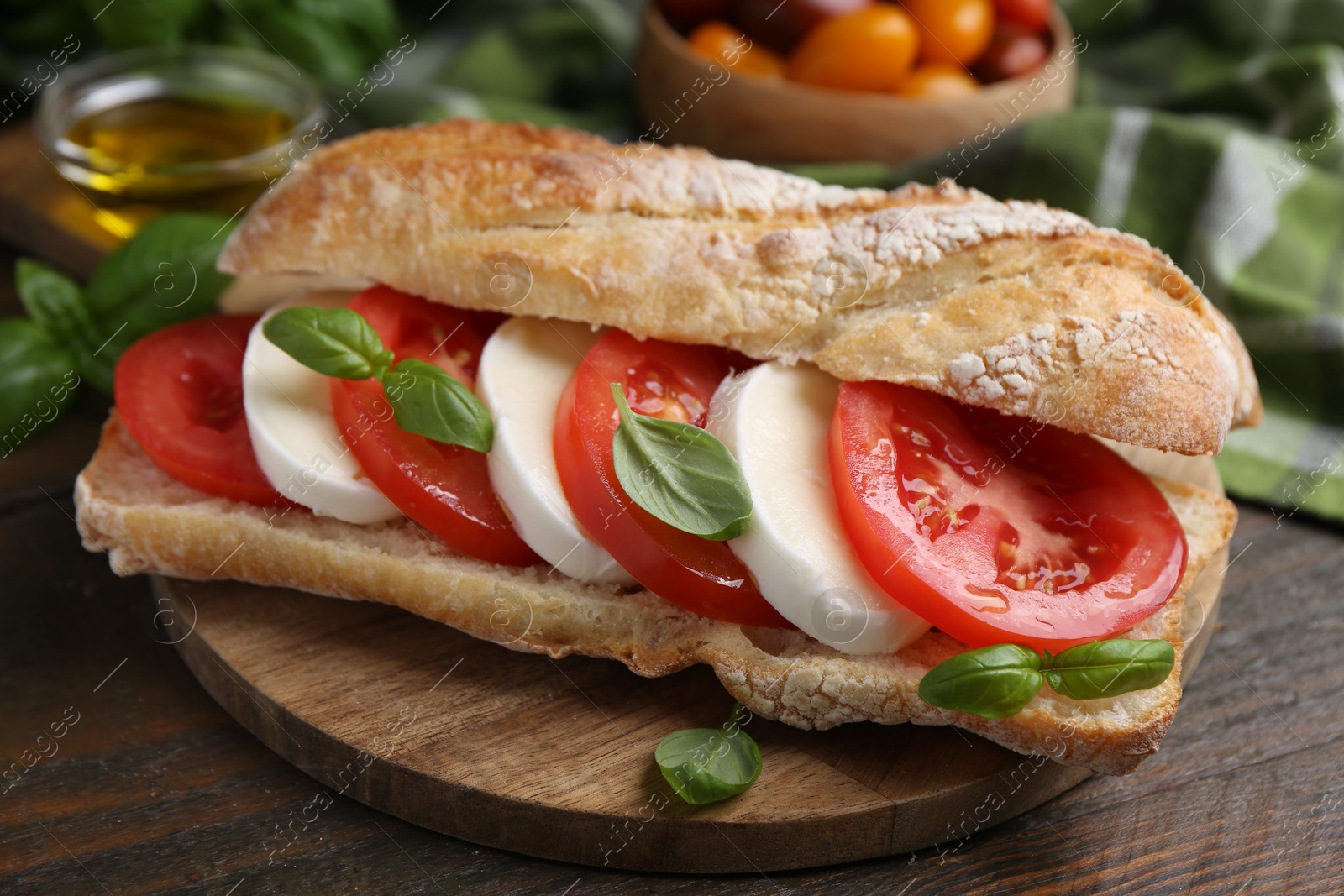 Tasty sandwich with mozzarella cheese, tomatoes and basil on wooden table, closeup Photo of Tasty sandwich with mozzarella cheese, tomatoes and basil on wooden table, closeup