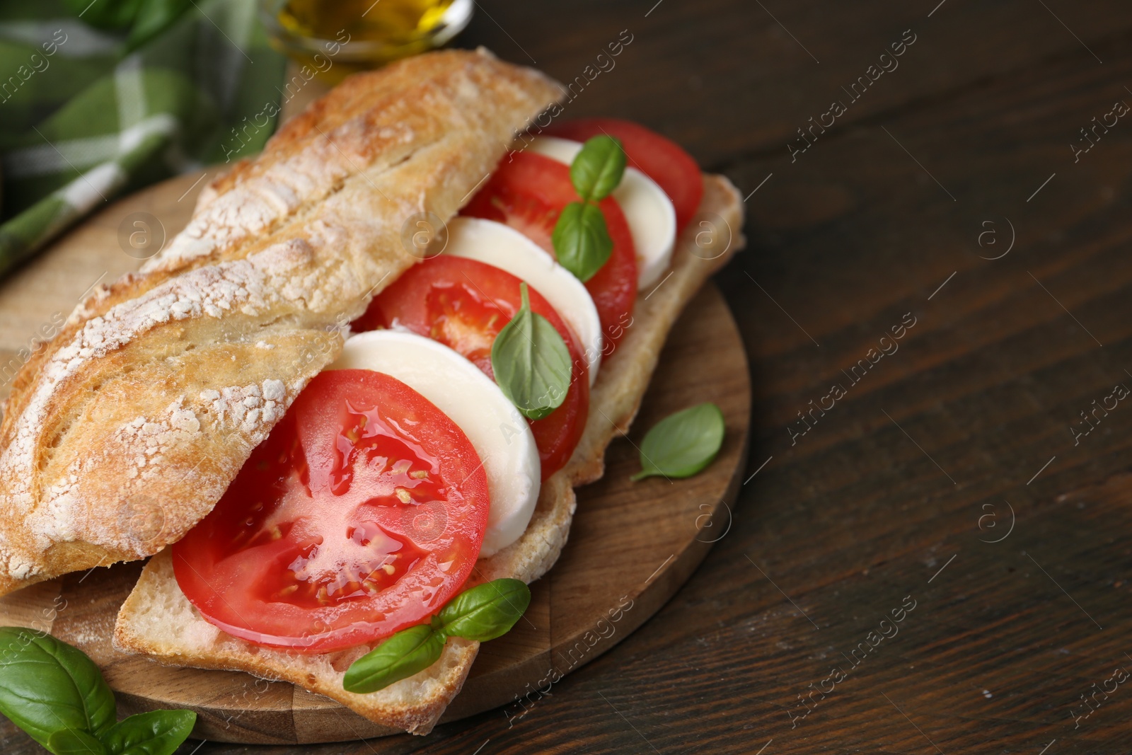 Tasty sandwich with mozzarella cheese, tomatoes and basil on wooden table, closeup. Space for text Photo of Tasty sandwich with mozzarella cheese, tomatoes and basil on wooden table, closeup. Space for text