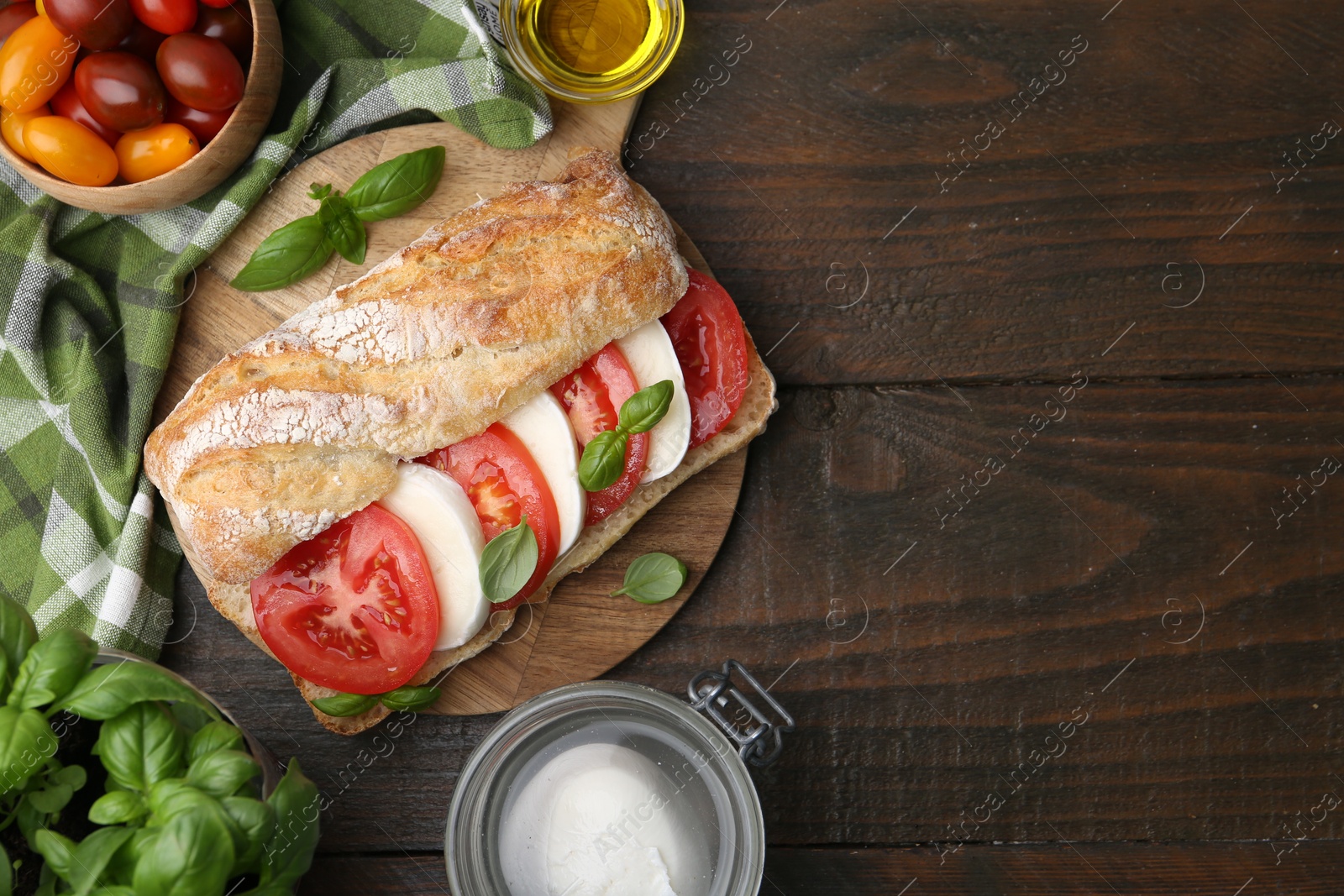 Tasty sandwich with mozzarella cheese, tomatoes and basil on wooden table, flat lay. Space for text Photo of Tasty sandwich with mozzarella cheese, tomatoes and basil on wooden table, flat lay. Space for text
