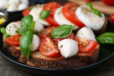 Photo of Tasty sandwiches with mozzarella cheese, tomatoes, basil and spices on wooden table, closeup