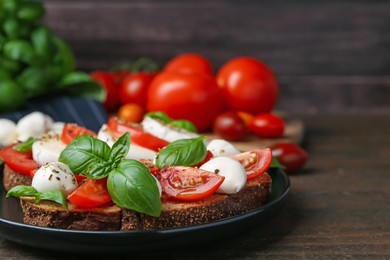 Photo of Tasty sandwiches with mozzarella cheese, tomatoes, basil and spices on wooden table against brown background, closeup
