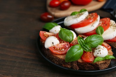 Photo of Tasty sandwiches with mozzarella cheese, tomatoes, basil and spices on wooden table, closeup. Space for text