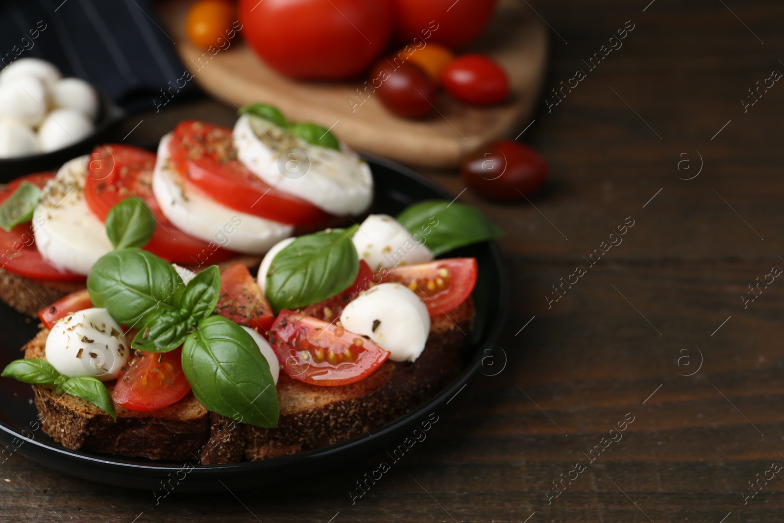 Tasty sandwiches with mozzarella cheese, tomatoes, basil and spices on wooden table, closeup. Space for text Photo of Tasty sandwiches with mozzarella cheese, tomatoes, basil and spices on wooden table, closeup. Space for text