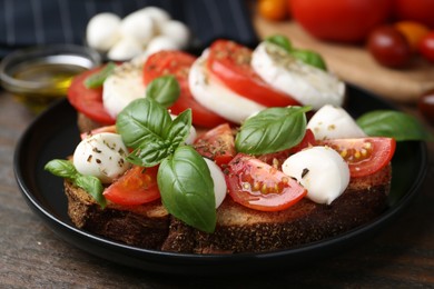 Photo of Tasty sandwiches with mozzarella cheese, tomatoes, basil and spices on wooden table, closeup