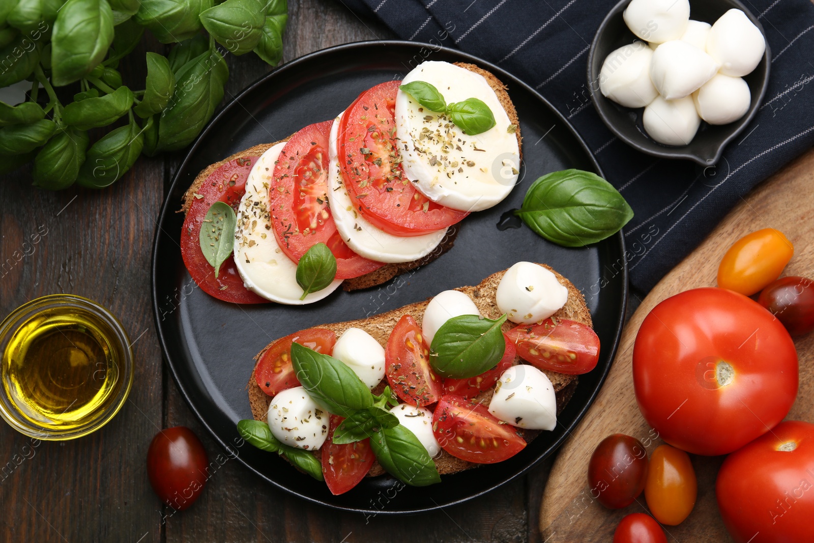 Tasty sandwiches with mozzarella cheese, tomatoes, basil and spices on wooden table, flat lay Photo of Tasty sandwiches with mozzarella cheese, tomatoes, basil and spices on wooden table, flat lay