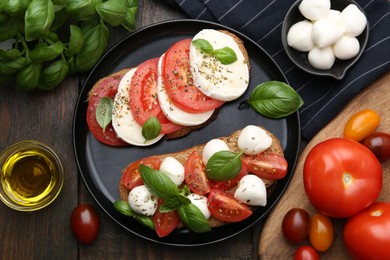 Photo of Tasty sandwiches with mozzarella cheese, tomatoes, basil and spices on wooden table, flat lay