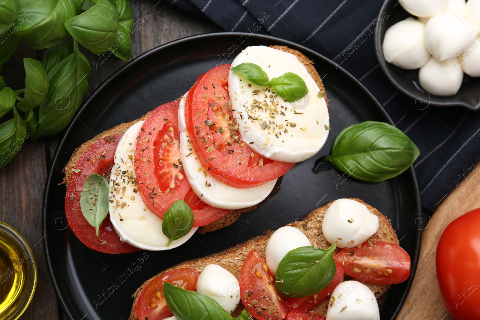 Tasty sandwiches with mozzarella cheese, tomatoes, basil and spices on wooden table, flat lay Photo of Tasty sandwiches with mozzarella cheese, tomatoes, basil and spices on wooden table, flat lay