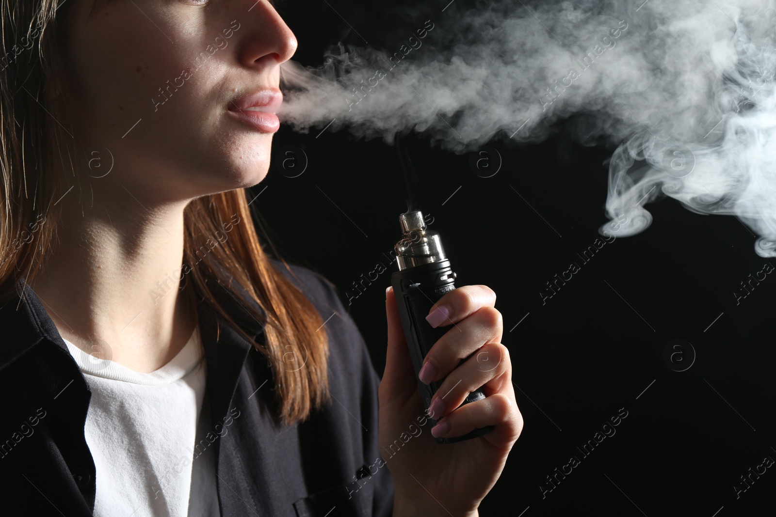 Woman using electronic smoking device on black background, closeup Photo of Woman using electronic smoking device on black background, closeup
