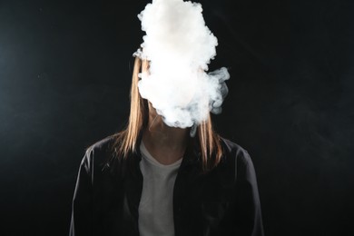 Photo of Woman using electronic smoking device on black background
