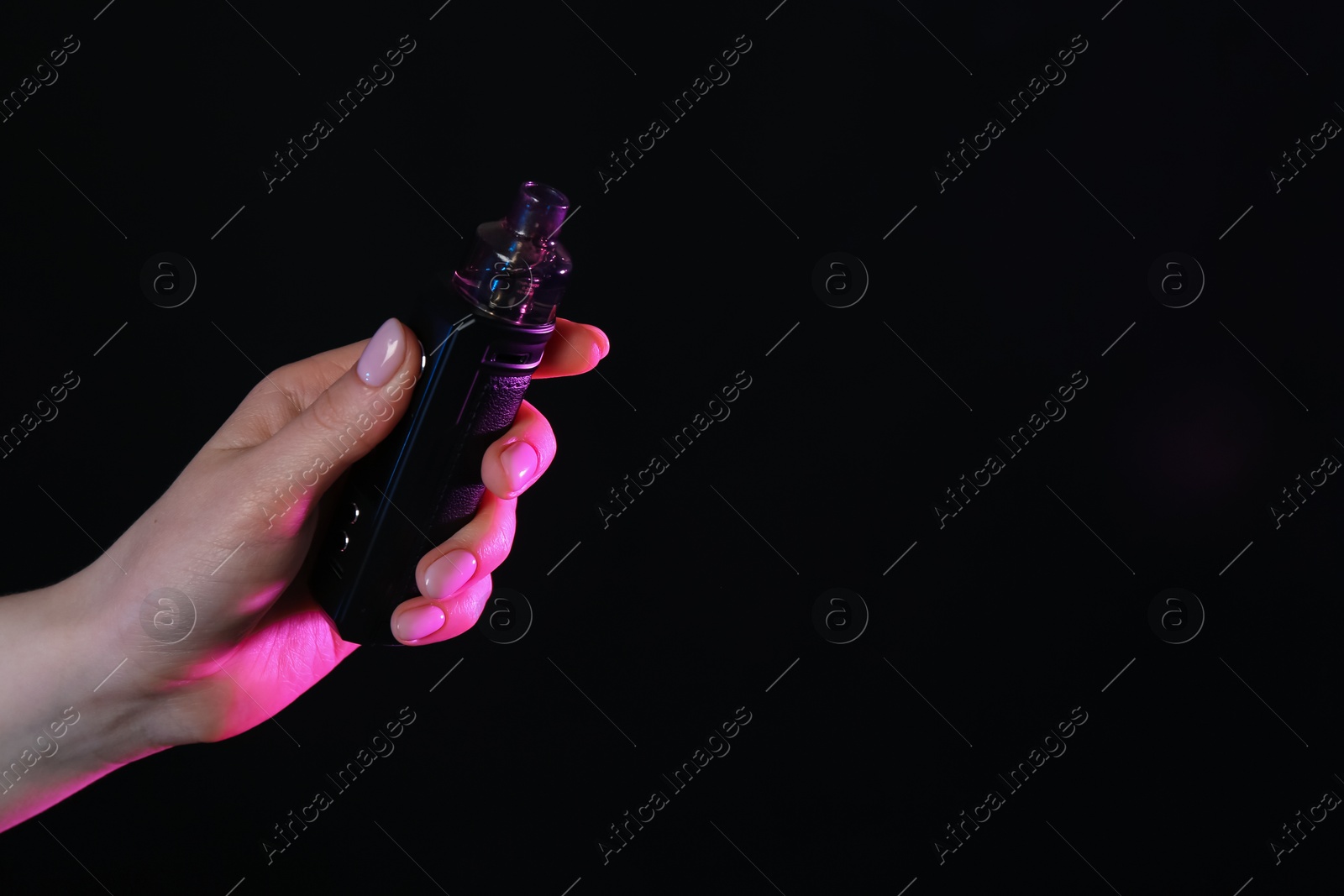 Woman with electronic smoking device in neon lights on black background, closeup. Space for text Photo of Woman with electronic smoking device in neon lights on black background, closeup. Space for text
