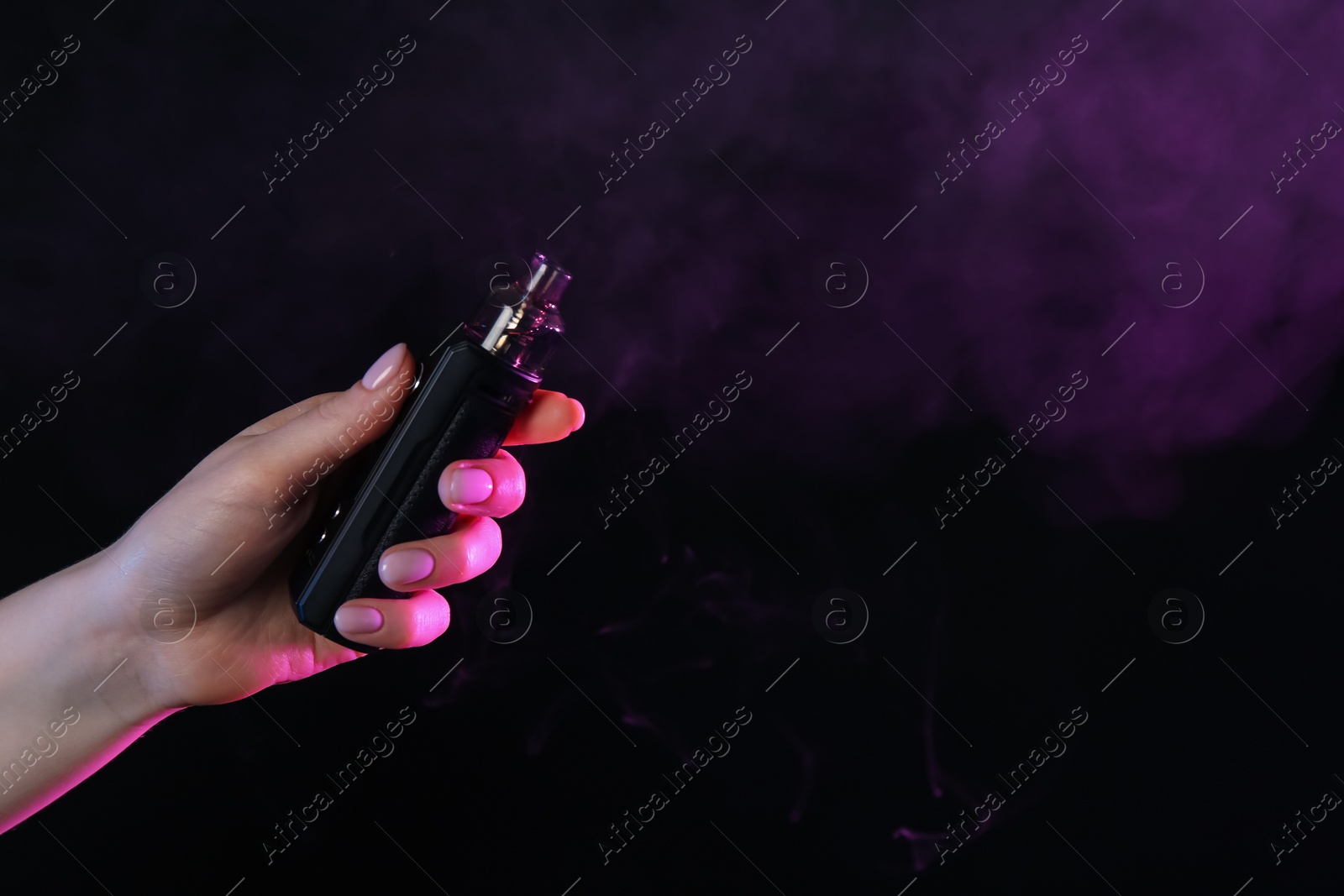 Woman using electronic smoking device in neon lights on black background, closeup. Space for text Photo of Woman using electronic smoking device in neon lights on black background, closeup. Space for text