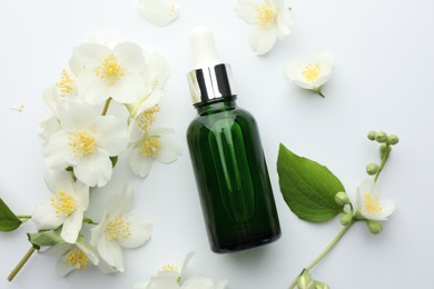Photo of Essential oil, jasmine flowers and green leaf on white background, flat lay