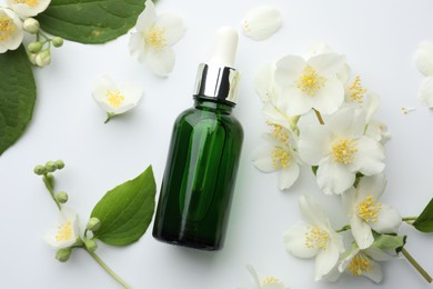 Photo of Essential oil, jasmine flowers and green leaves on white background, flat lay