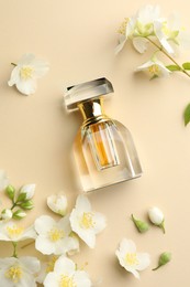Photo of Bottle of perfume and beautiful jasmine flowers on beige background, flat lay