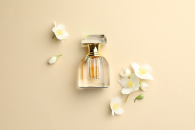 Photo of Bottle of perfume and beautiful jasmine flowers on beige background, flat lay