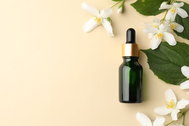 Photo of Essential oil, beautiful jasmine flowers and green leaves on beige background, flat lay. Space for text